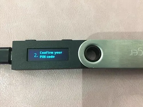 Pantalla de la billetera de hardware solicitando volver a ingresar el PIN y confirmar con los botones laterales