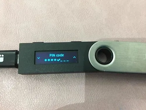 Pantalla del Ledger Nano S indicando que se debe hacer copia de seguridad de las 24 palabras de recuperación