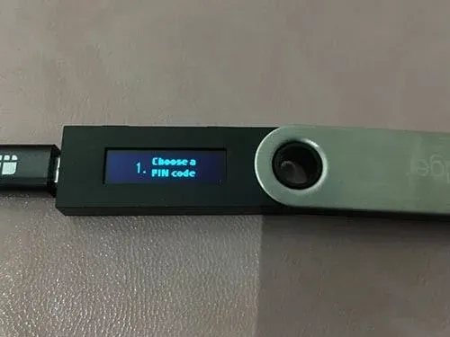 Pantalla del Ledger Nano S mostrando operación de desbloqueo con teclas numéricas y botones laterales