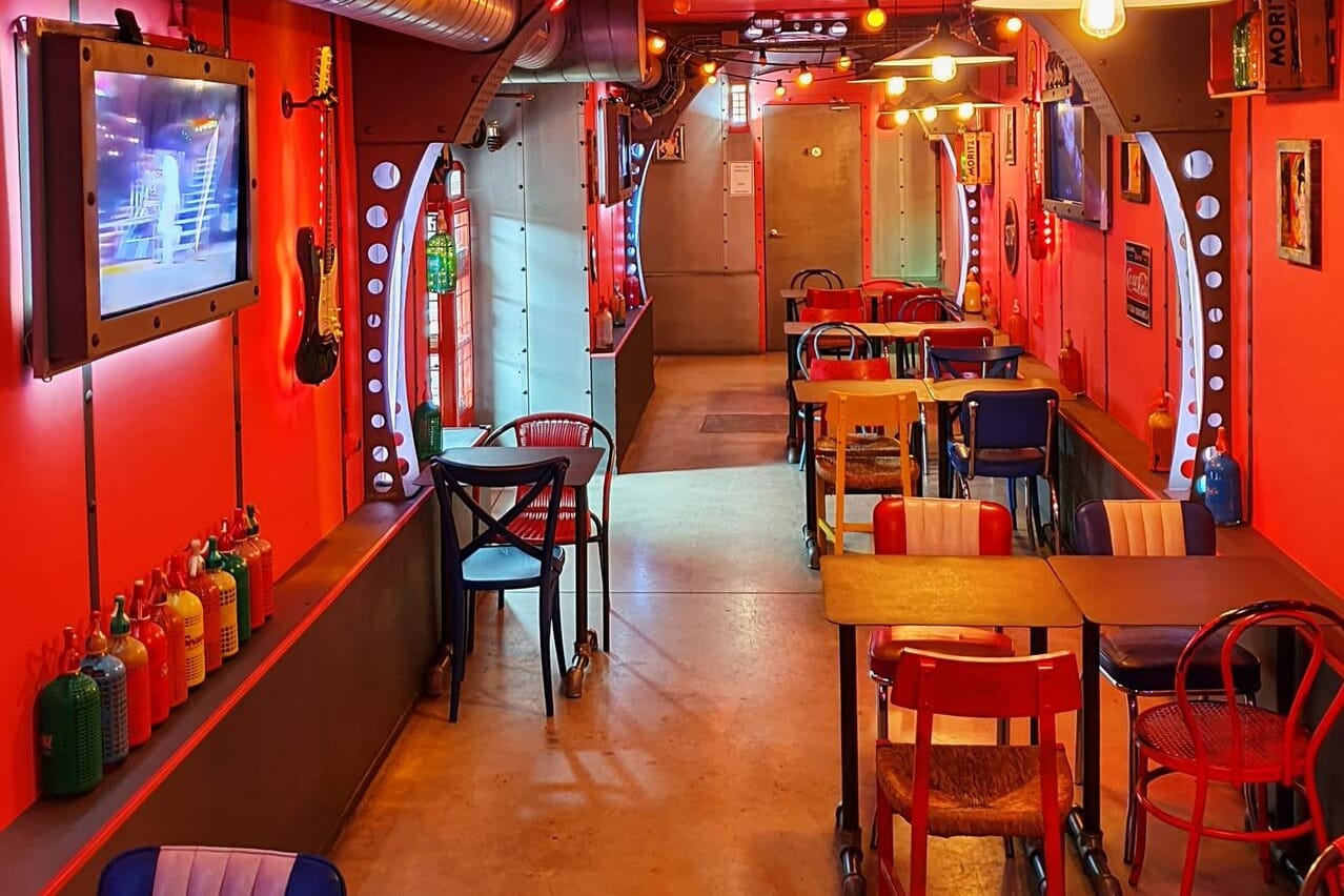 SODA BUS: "Restaurante temático 'SODA BUS' en Barcelona, con un auténtico autobús londinense en su interior y decoración rockera, perfecto para eventos informales y festivos.