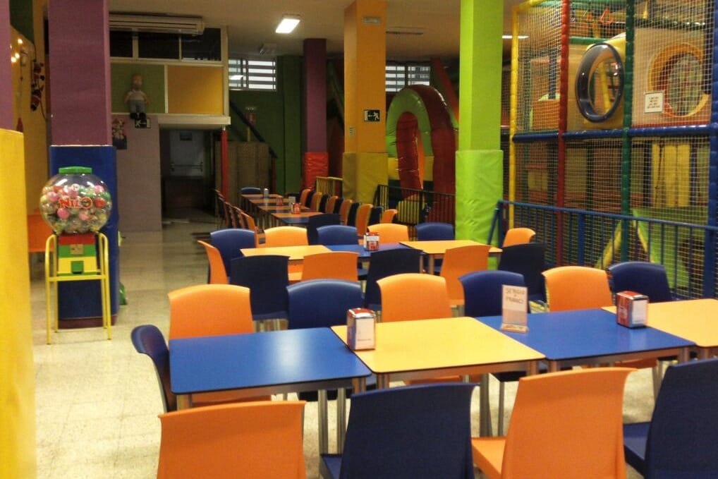 Niños corriendo y jugando entre colchonetas y juegos en Krusty Park.