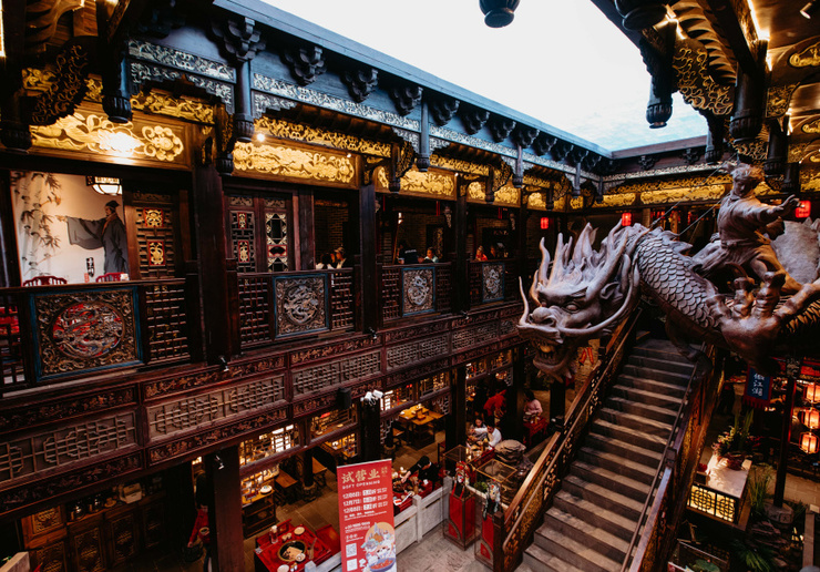 A two-storey Chinese restaurant with a large dragon statue in the centre.