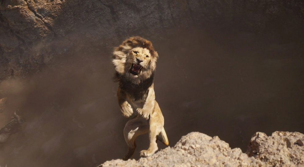 Still from Lion King (2019) a photorealistic lion falls into a dirty brown gorge.
