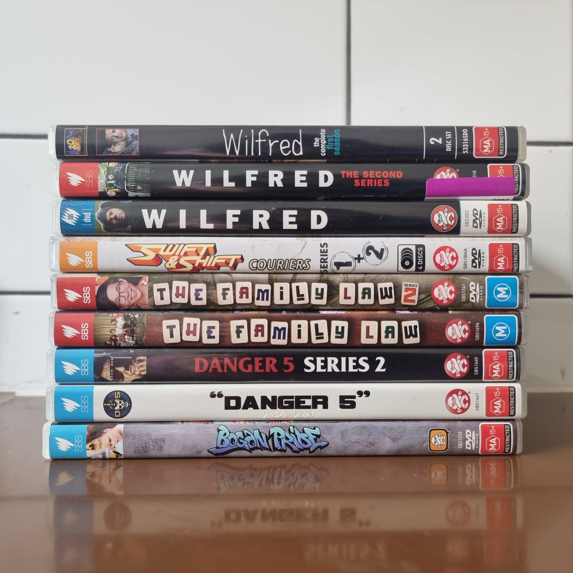A stack of DVDs. Bogan Price, Danger 5 series 1 and 2, The Family Law 1 and 2, Swift and Shift Couriers 1 and 2, Wilfred 1 and 2, and the American Wilfred remake.