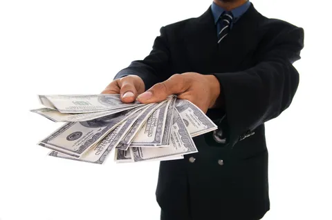 Man holding cash and calculator representing financial management concepts