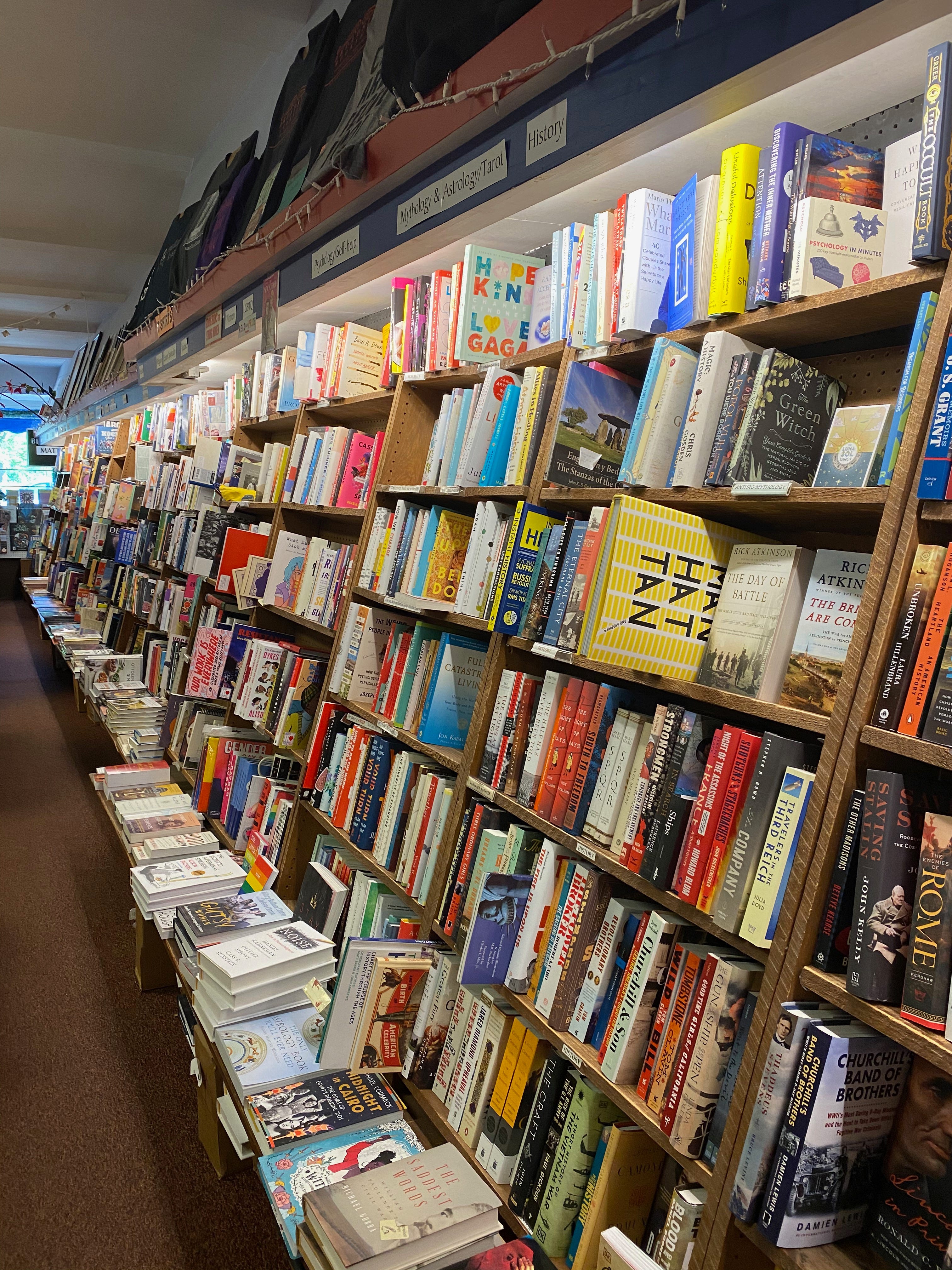 A long row of floor-to-ceiling shelves in a bookshop.