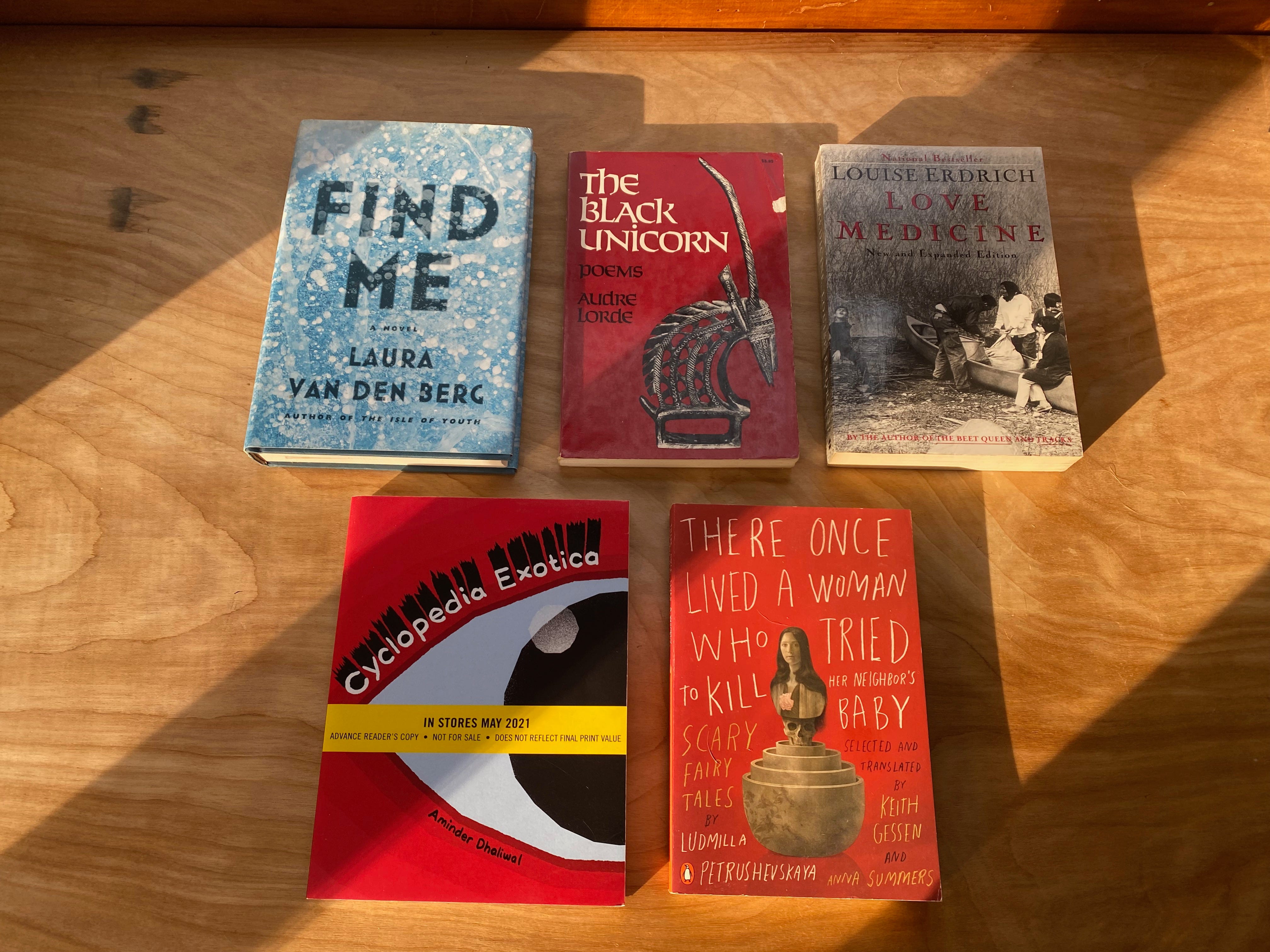 The five listed books laid out on a sunny desk.