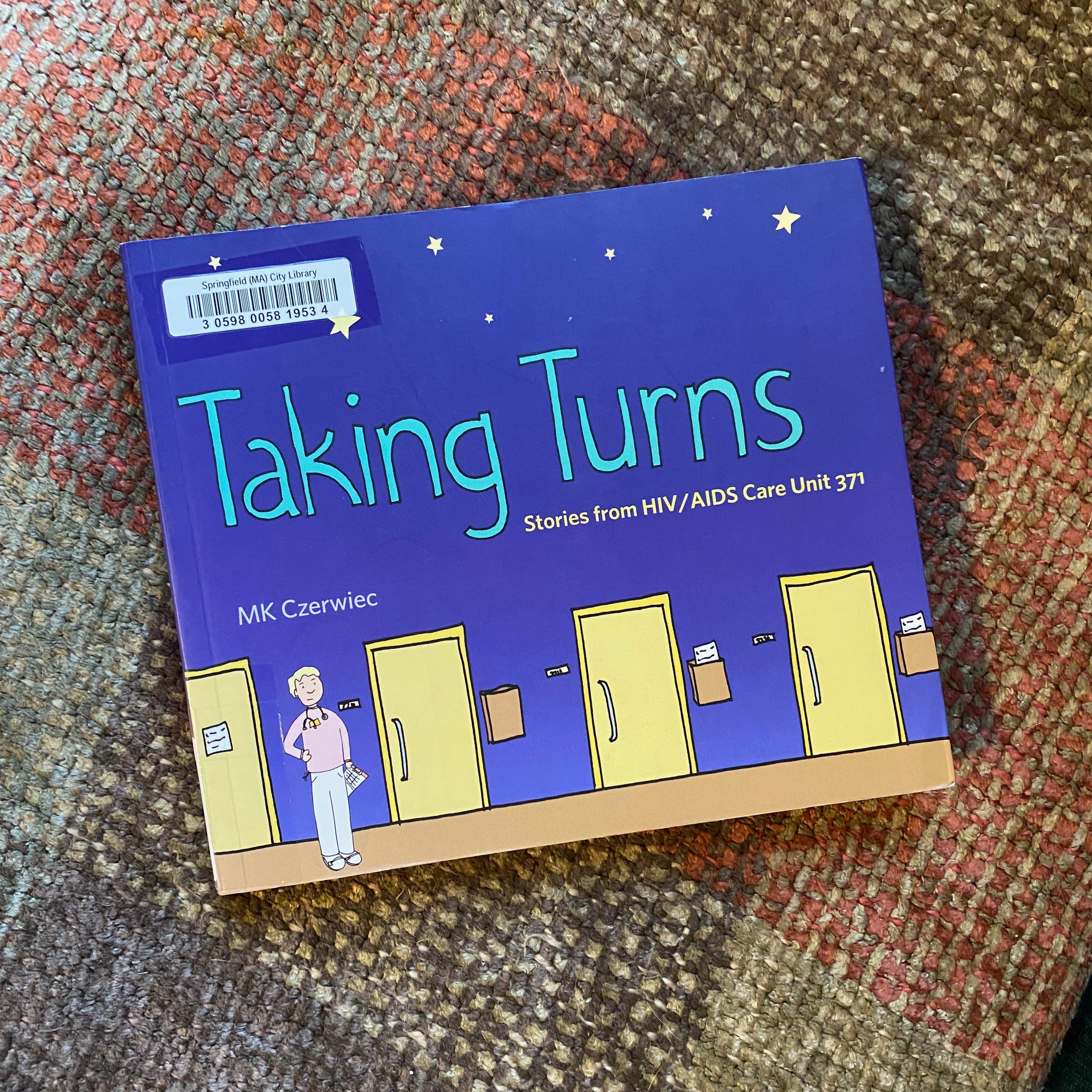 Taking Turns lying on a red and green blanket.