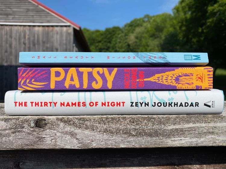 The three featured books sit on a wooden railing, with a weathered barn and some trees in the background.