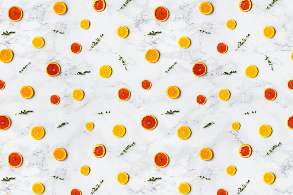 Colorful citrus slices arranged in a flat lay pattern on a marble surface, ideal for backgrounds.