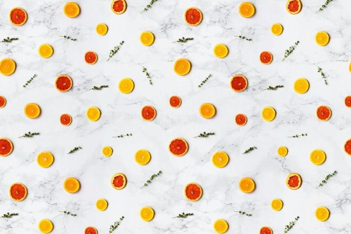 Colorful citrus slices arranged in a flat lay pattern on a marble surface, ideal for backgrounds.