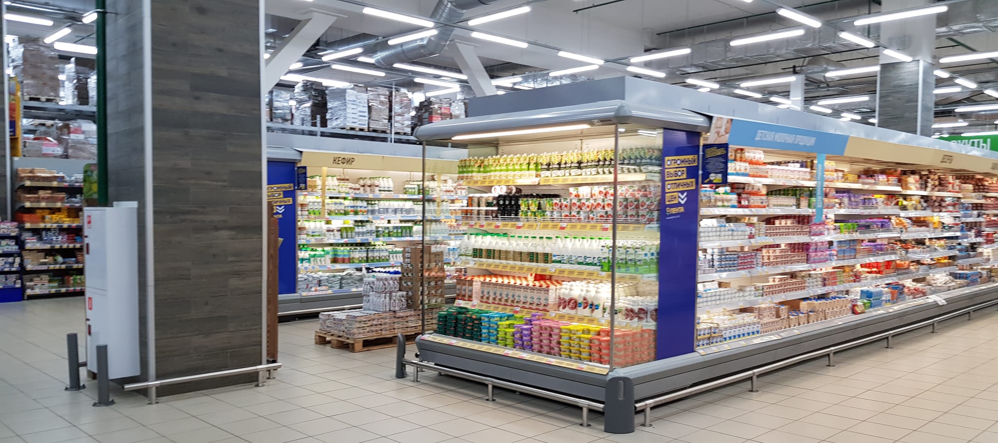 Refrigerator section of the supermarket with drinks and food on the shelves.