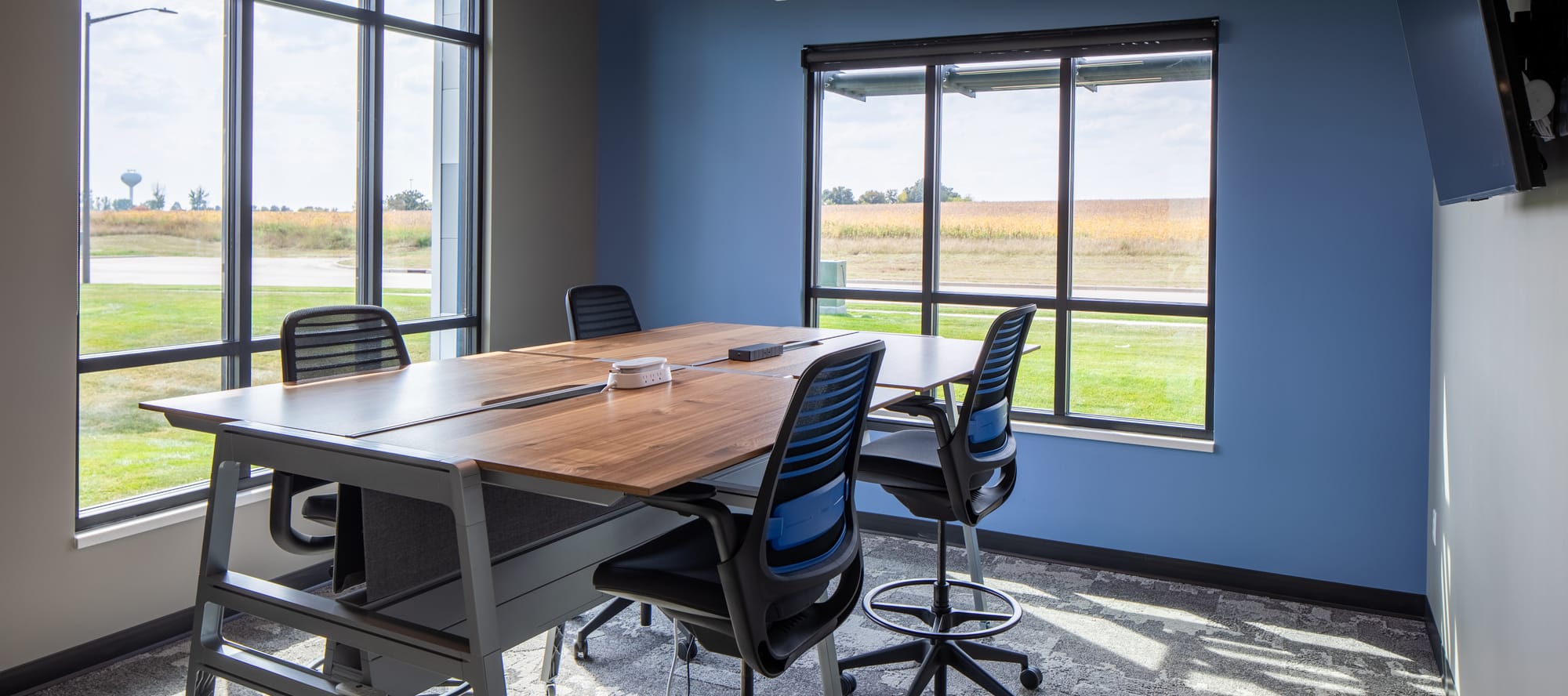 Photo of Grafe Auction's small conference room at our office in Stewartville, MN. Conference table with 4 chairs, blue wall