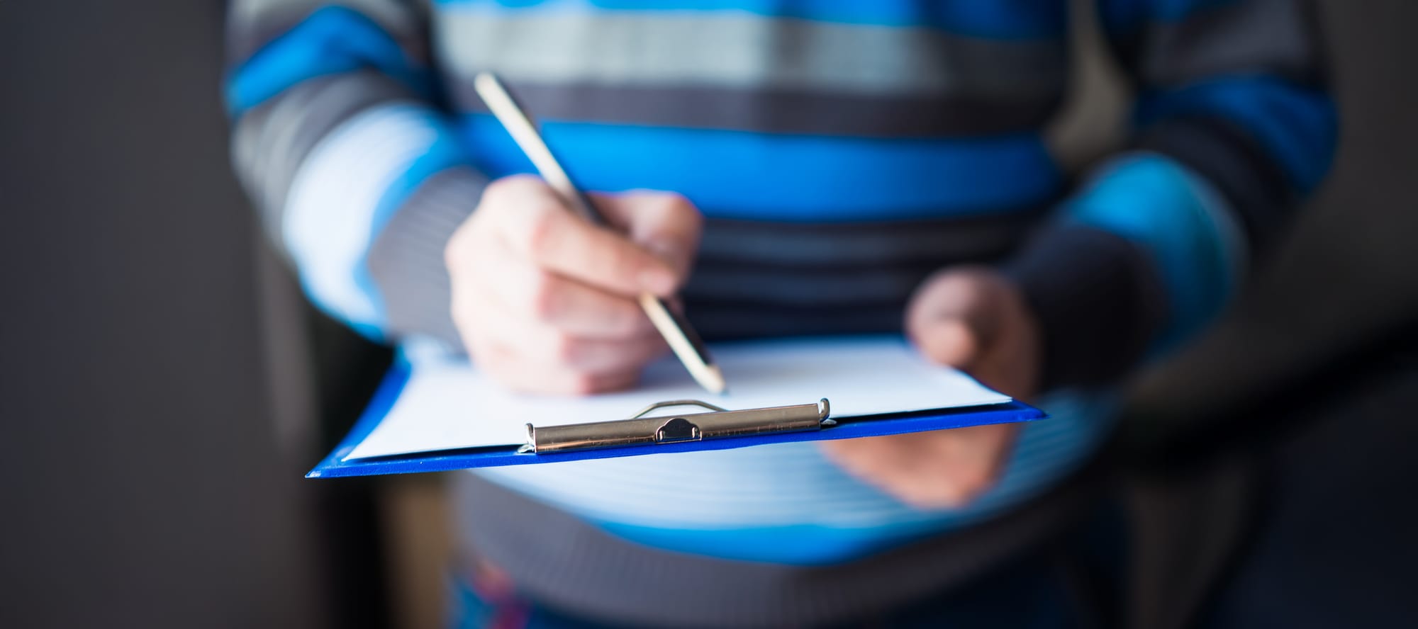 Business person holding a clipboard with inspection day checklist.