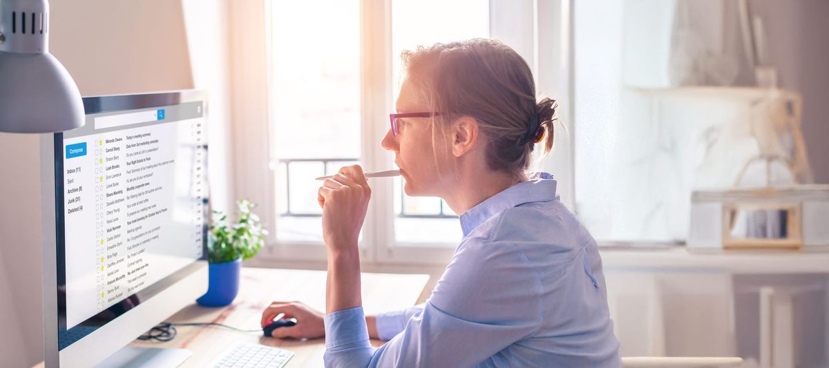 Person looking through email on computer screen at work