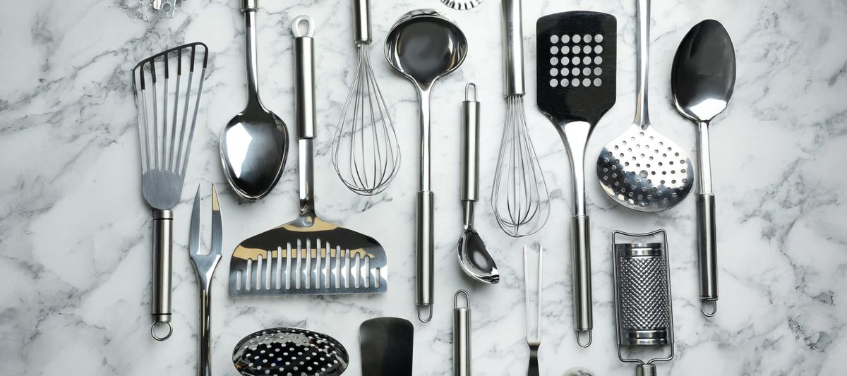 Different kitchen utensils on marble background