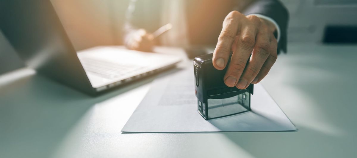 Businessman putting a stamp on business license in an office.