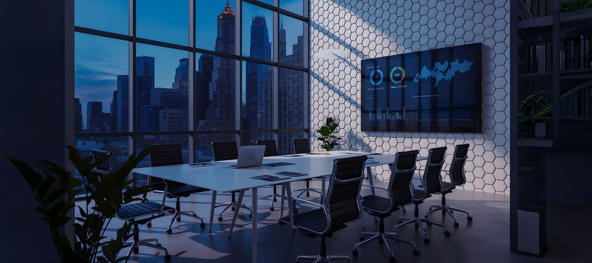 Conference room with large windows and city view at dusk with screen on wall