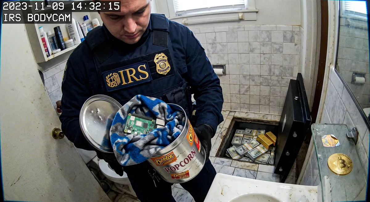 An IRS Criminal Investigation agent recovers a single-board computer hidden in a popcorn tin during the search