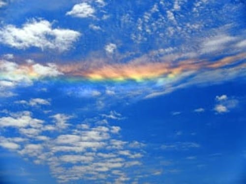 Photo of 'sundog' rainbow of colors across blue sky