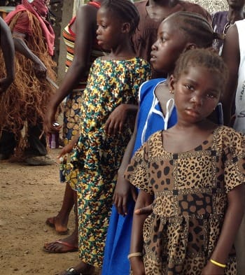 Photo of Sierra Leonean girls in colorful clothing at a village gathering.