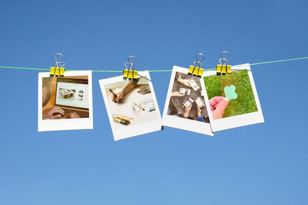 Four Polaroid instant photos hanging on a clothes line to dry