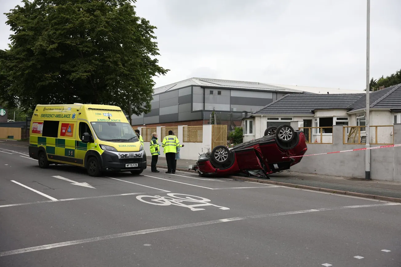 Driver rushed to hospital after car smashes into wall and flips onto roof