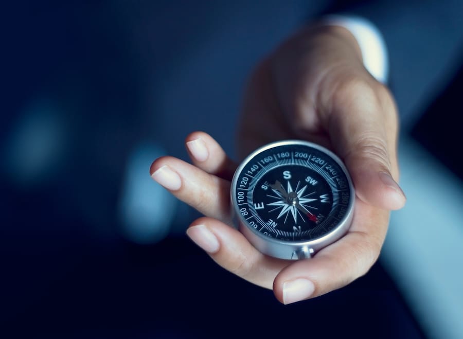 Hand holding compass trying to figure out which way the S&P will go