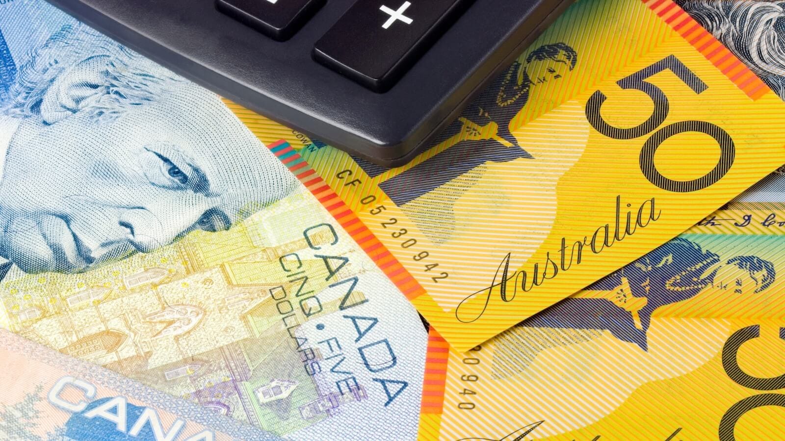 Canadian and Australian dollar bills with manual calculator