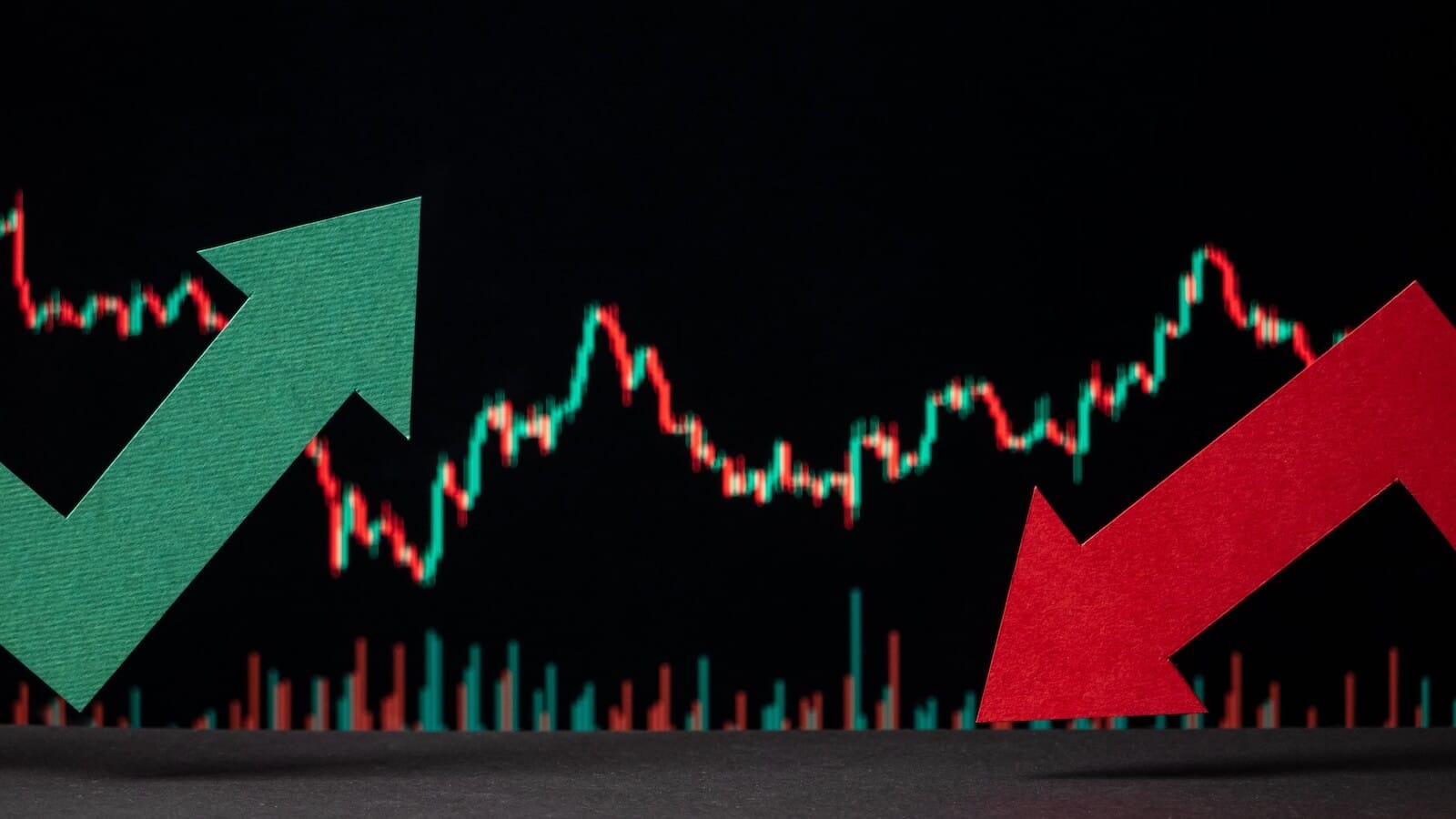 Stock chart in the background with one green arrow pointing up and a red arrow pointing down