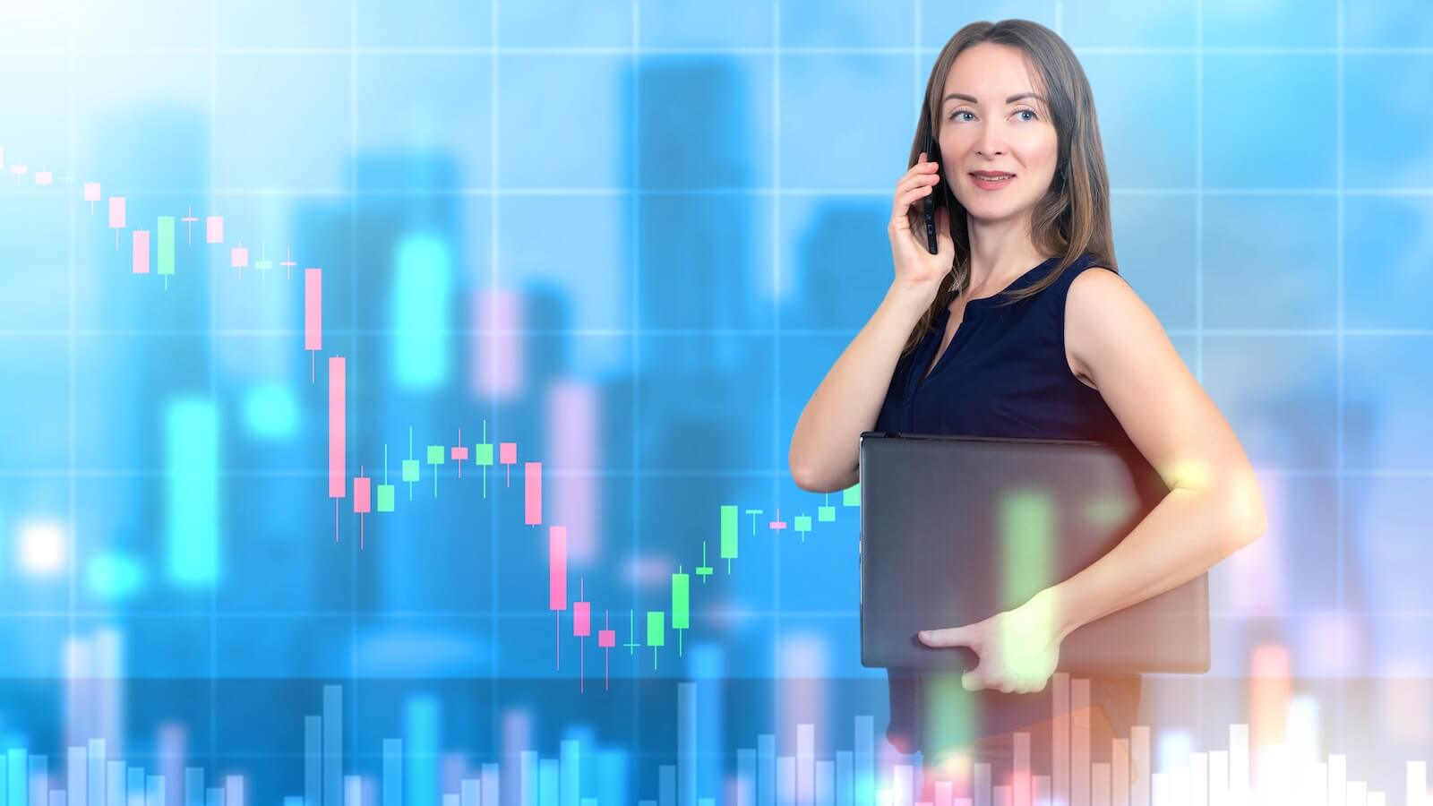 Woman investor on phone with falling graph in background: buy the dip