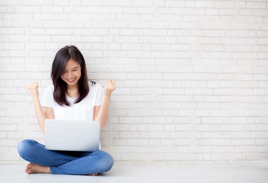 Happy young girl sitting on floor: stocks break out to new highs