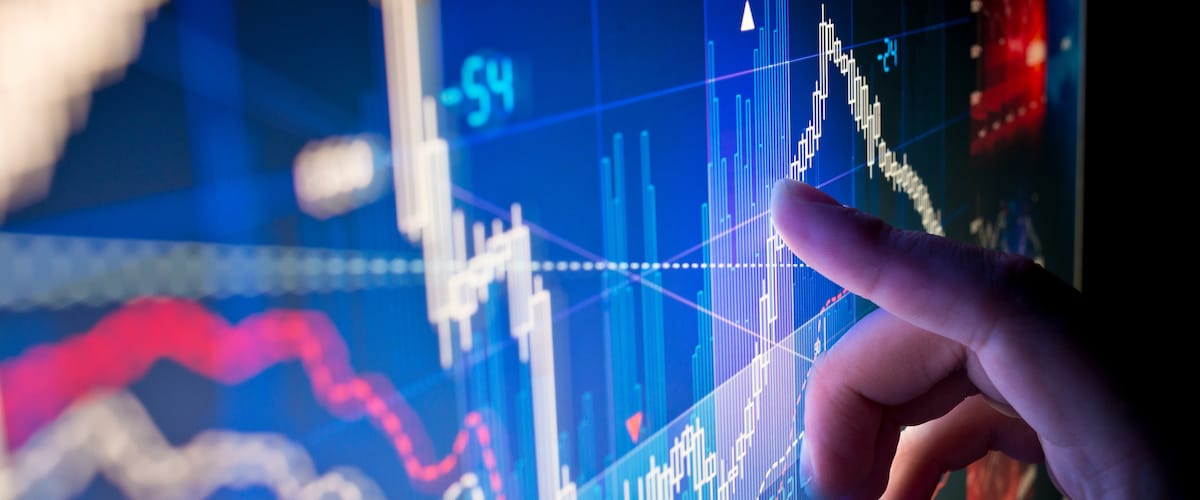 Person pointing to chart on screen: RSI signal