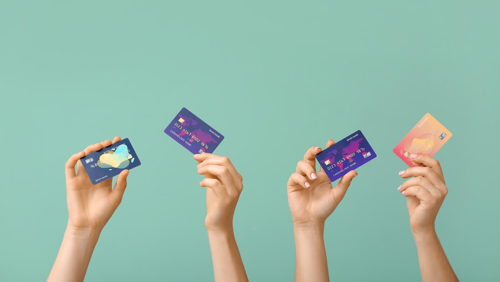 hands with credit cards: Visa and Mastercard stock prices hit record high