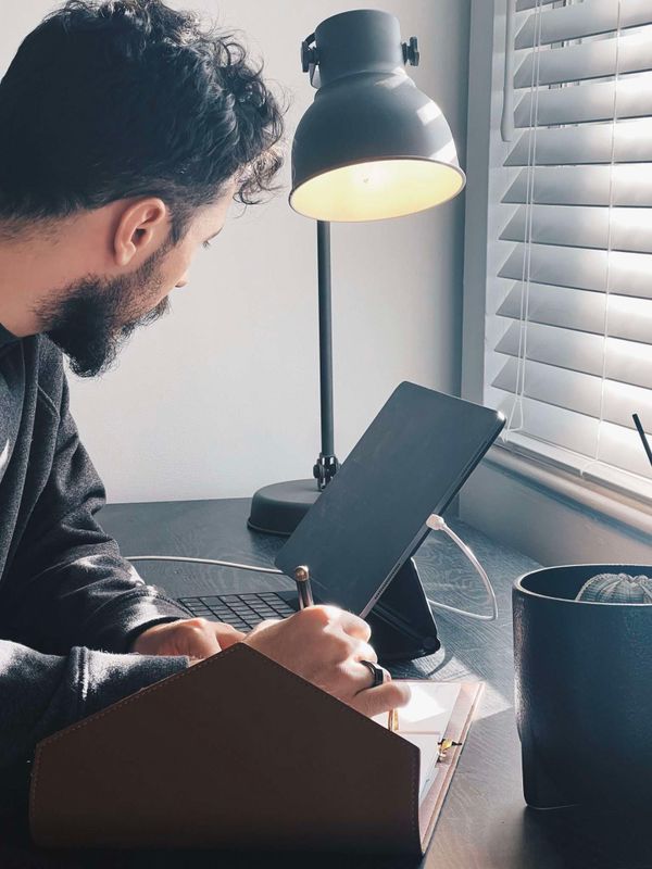 A picture of me looking at my ipad as I write down my schedule in my weekly planner
