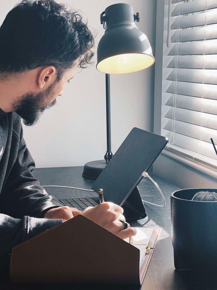 A picture of me looking at my ipad as I write down my schedule in my weekly planner