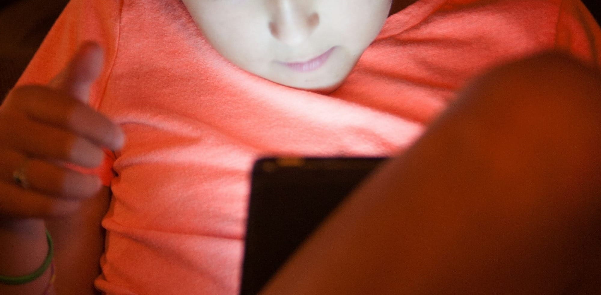 Young girl focused on her tablet screen.