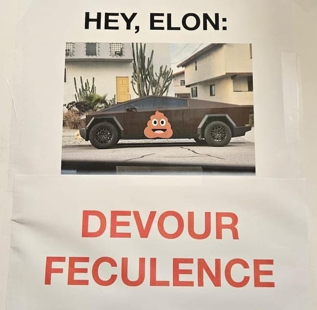 A sign with a picture of a brown Cybertruck with a poop emoji on it and the words "Hey, Elon, Devour Feculance"