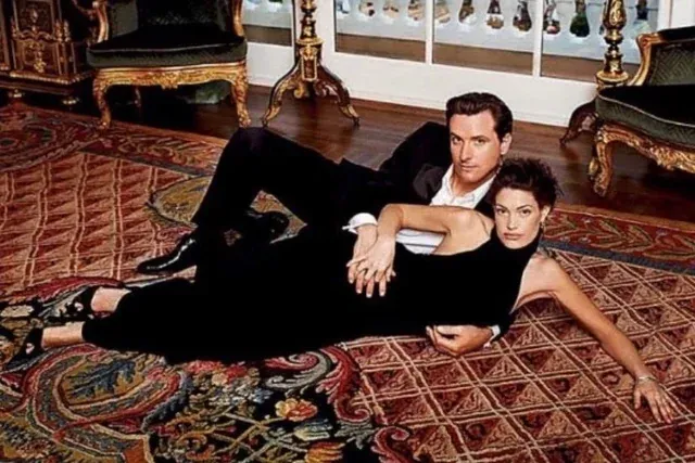 2004 picture of then SF Mayor Gavin Newsom and his then-wife Kimberly Guilfoyle, dressed in black and posing on an area rug.