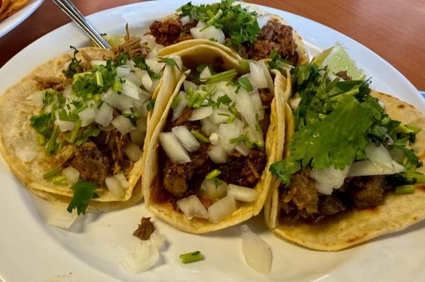 Close-up of tacos at La Peña Mexicana in Kennett Square, fresh tortillas filled with seared meats, topped with onion and cilantro.