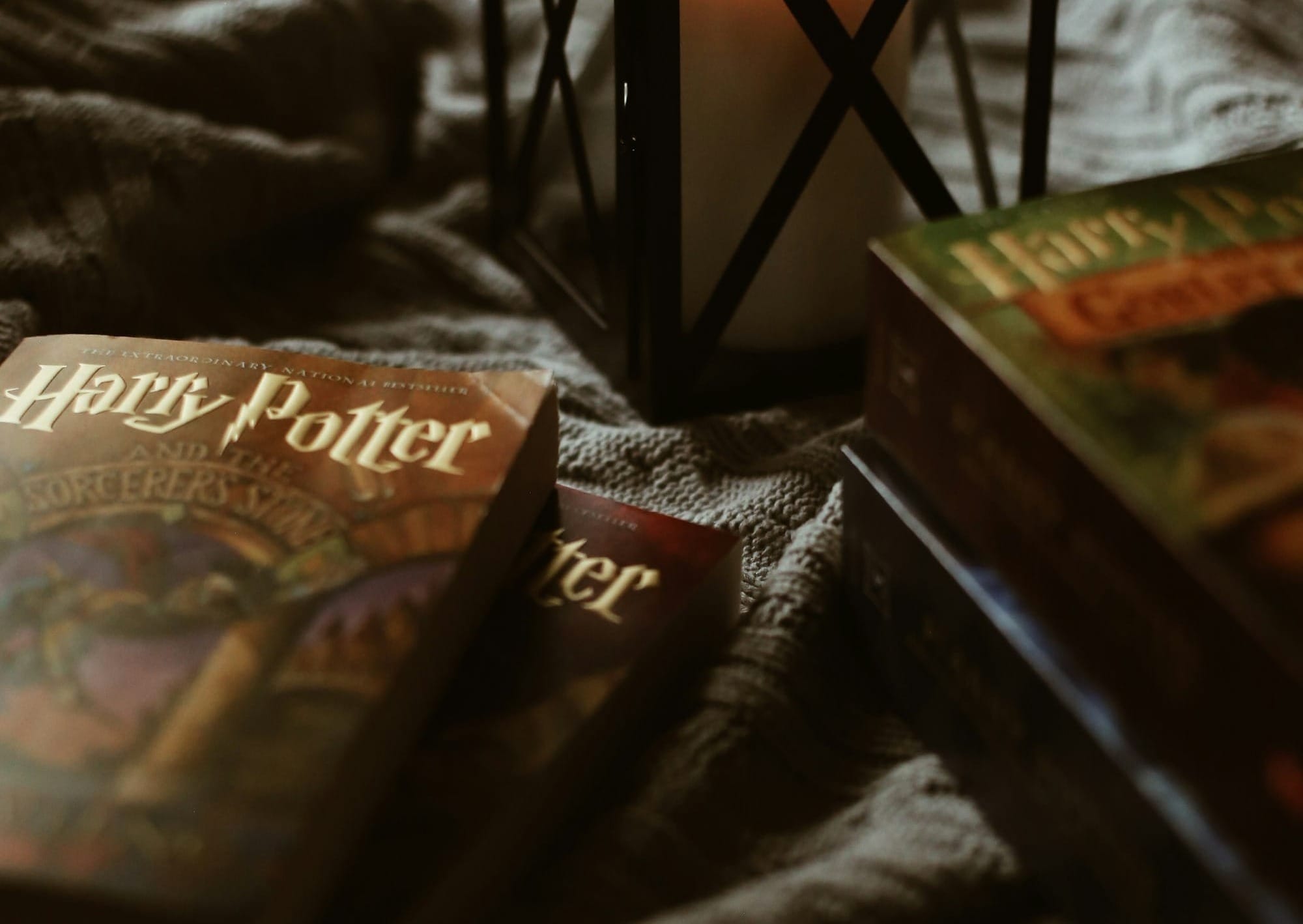 a candle sitting on top of a bed next to two books
