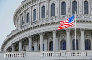 An American flag in frount of the US Capital - Getty Images - Unsplash