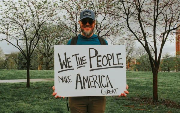 Man with a "We the People Make America Great" sign - Barbara Burgess - Unsplash
