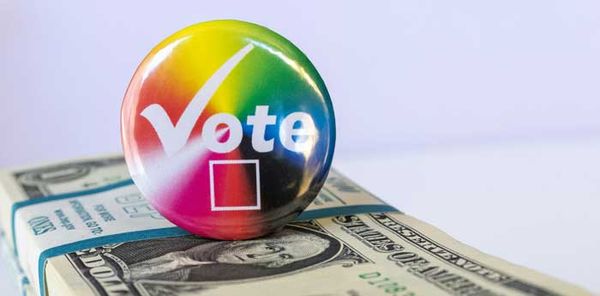 a Vote button on top of a stack of dollar bills - Sebastian Enrique - Unsplash