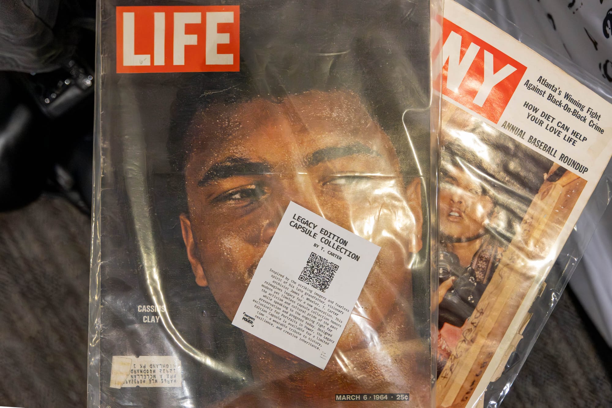 On a table, two magazines sit stacked, the front featuring a Life cover with a man.