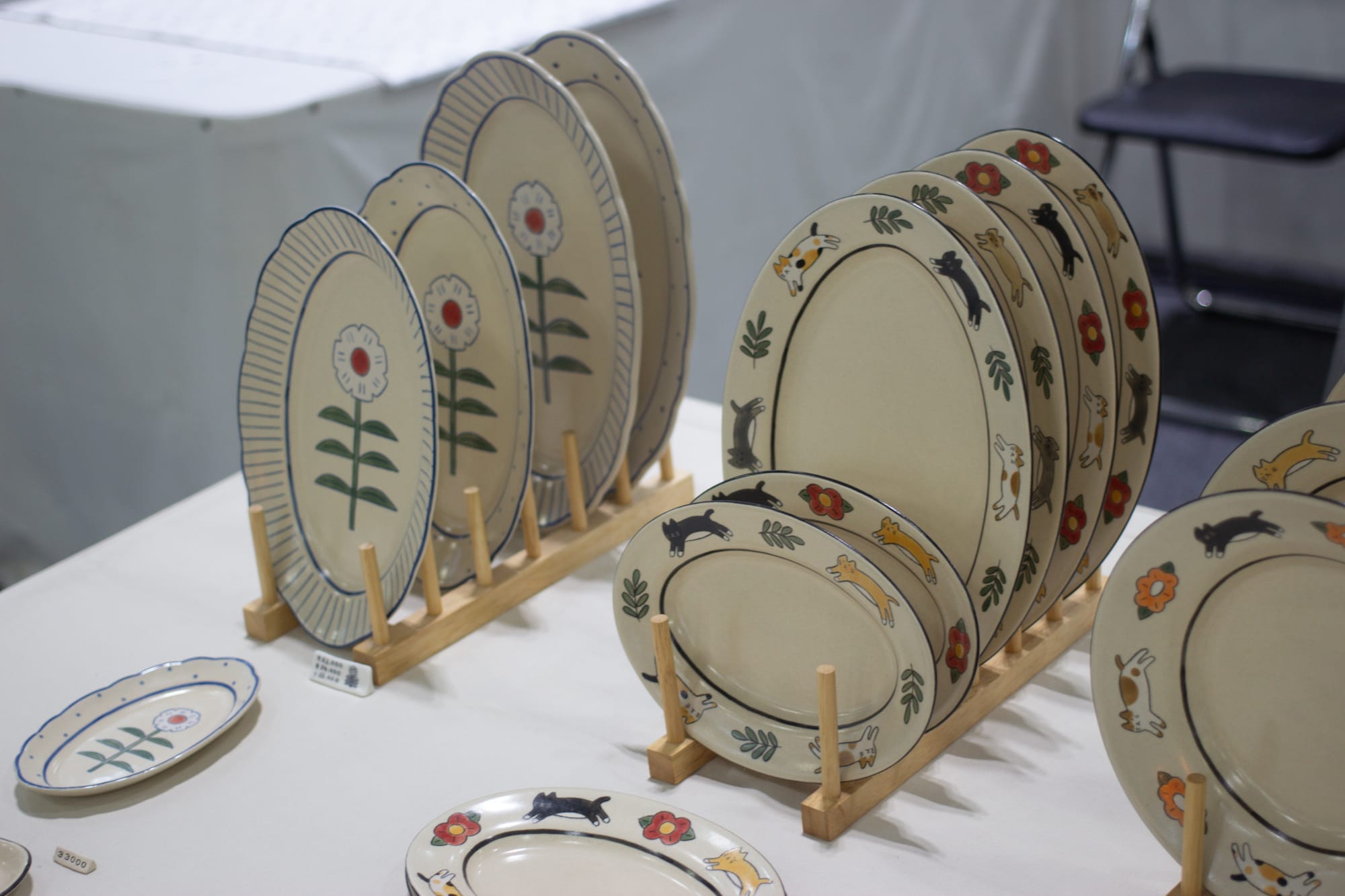 Plates with iconographic designs around the rims and, on some, in the center. They depict flowers and cats.