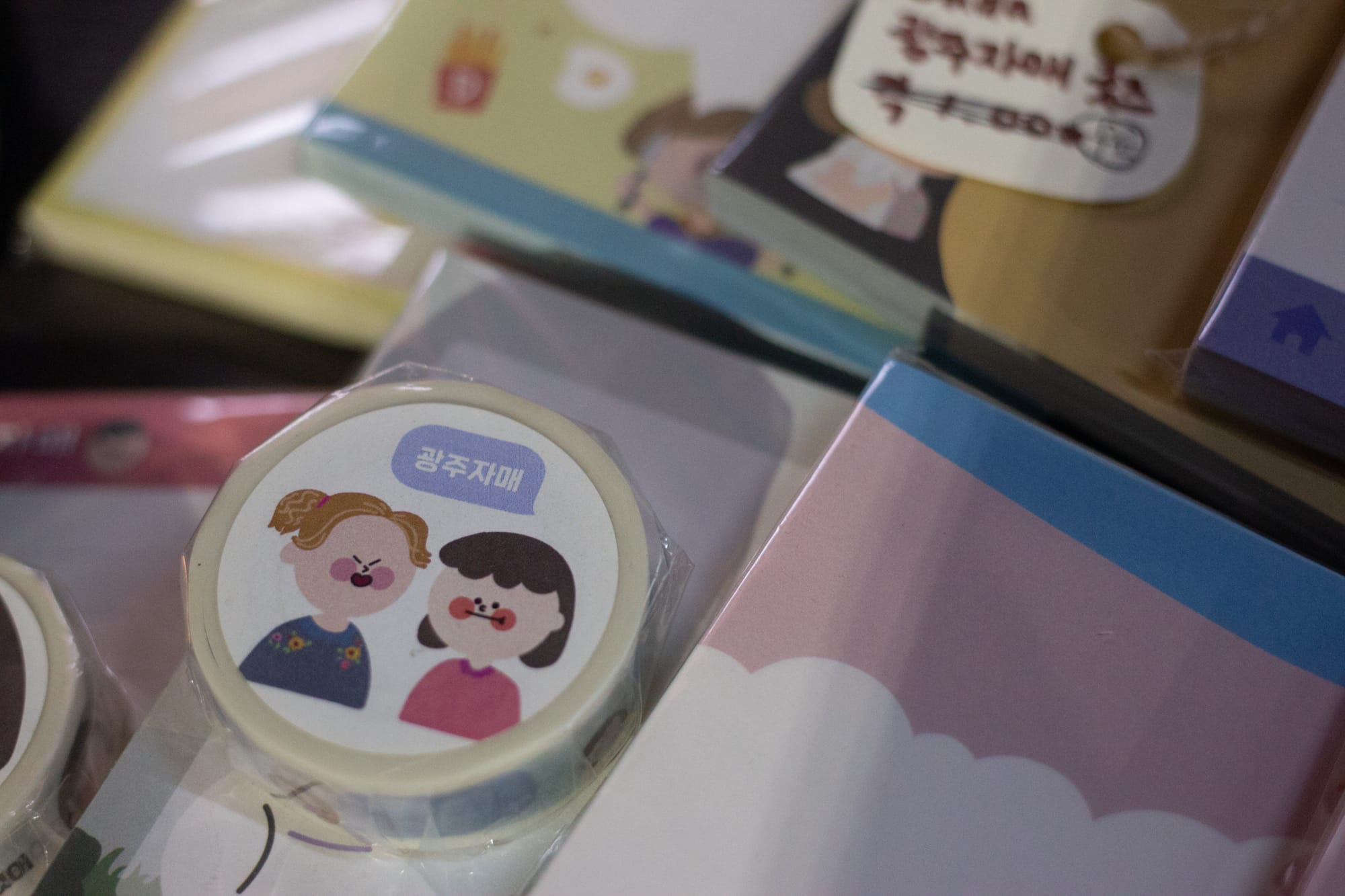 A package of washi tape with two cartoon girls on a display with other cartoon-decorated stationery.