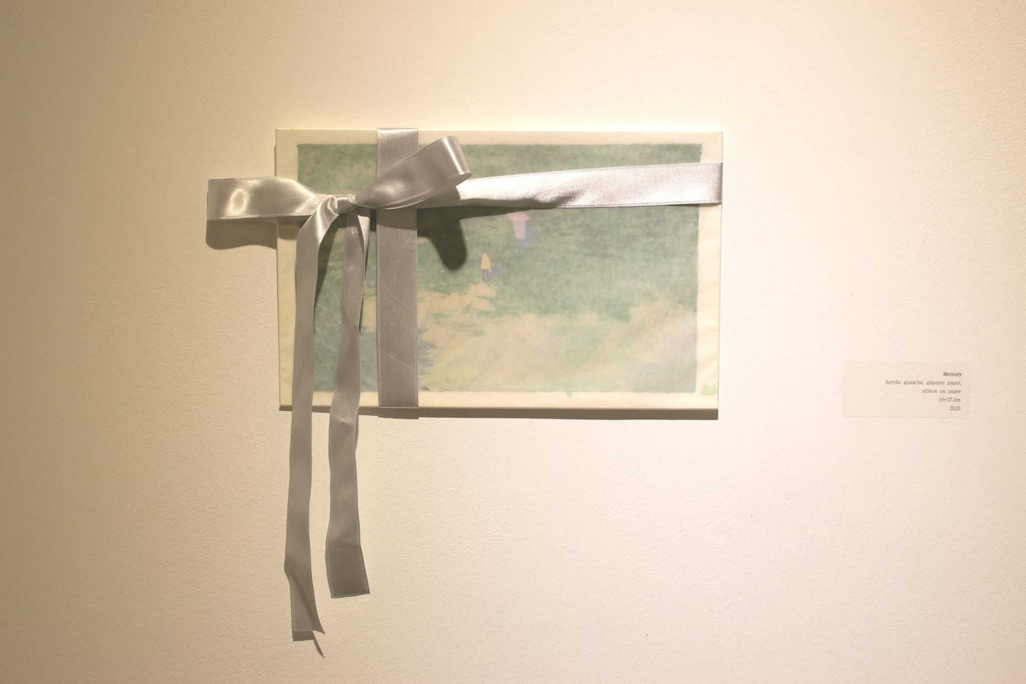 An art piece on paper, depicting two figures walking among shadows of trees. There is a white border. The piece is covered with translucent paper and wrapped in a silvery bow.