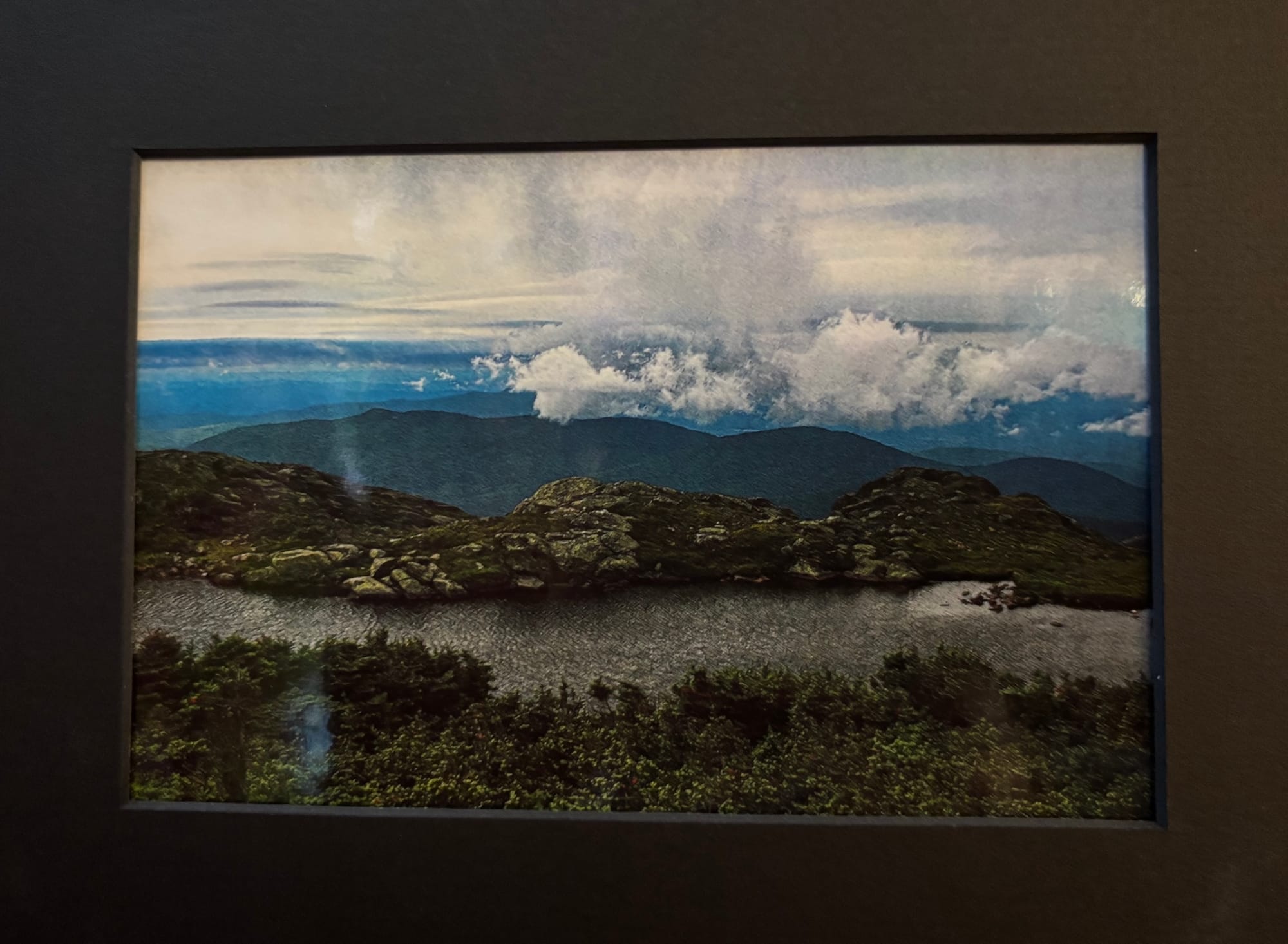 A photo of a lake, with mountains in the background.