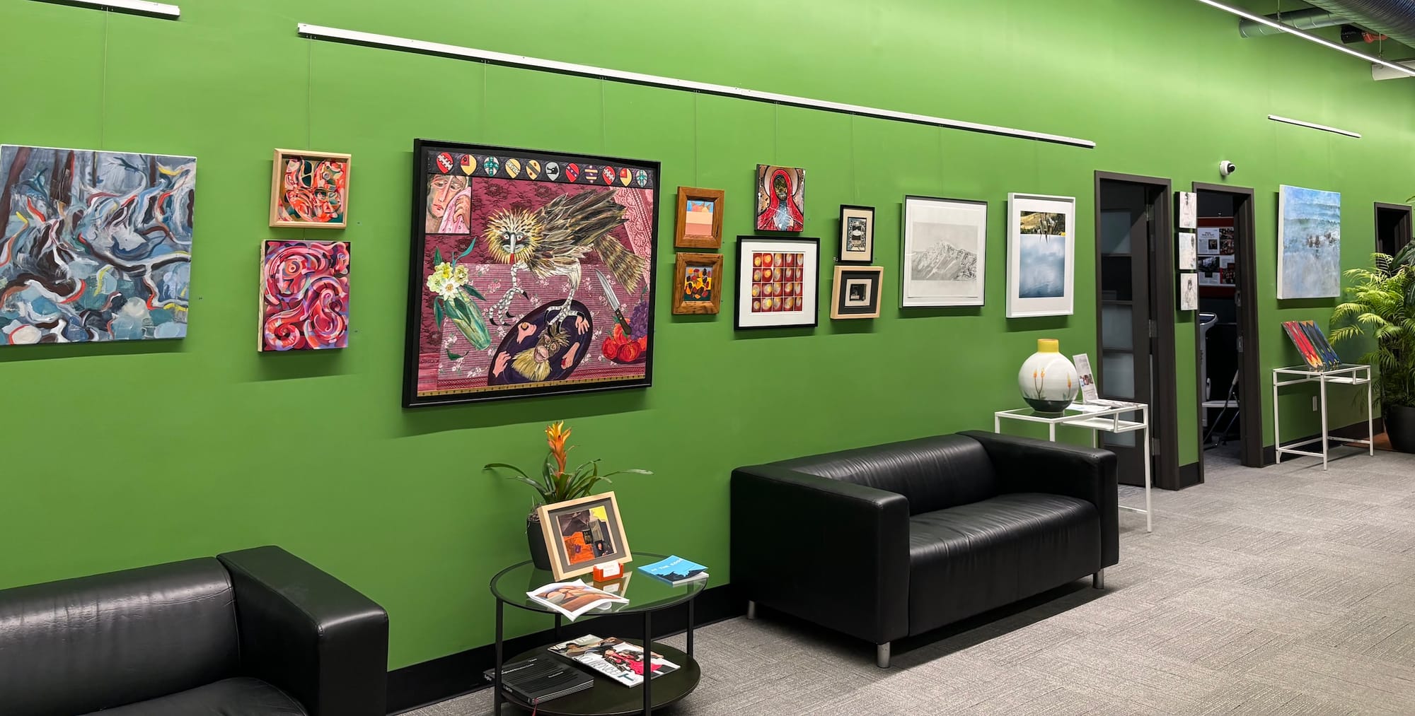 A photo of more artwork in the gallery, with some couches in frame.